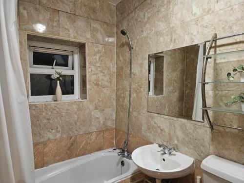 a bathroom with a sink and a toilet and a tub at Mitcham Junction - 2 Bed Apartment - Sleeps 6 in London