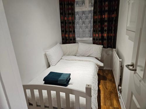 a small bed in a small room with a window at Mitcham Junction - 2 Bed Apartment - Sleeps 6 in London