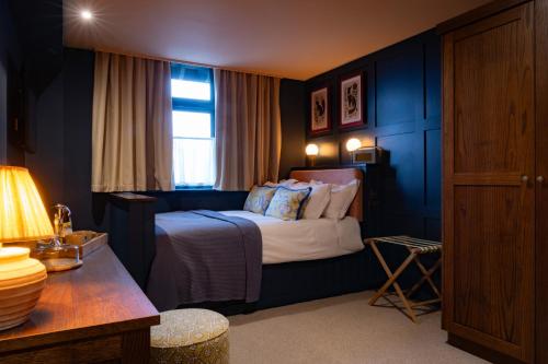 a hotel room with a bed and a table at The Royal Forest - A Heartwood Inn in Chingford