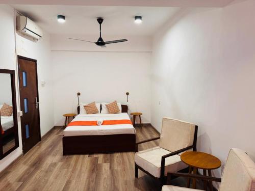 a bedroom with a bed and a couch and a chair at CityRest Fort in Colombo