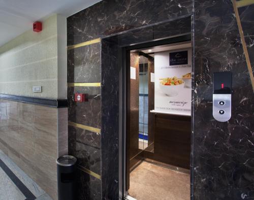 a elevator in a building with a sign on the wall at Ananyas Nest in Coimbatore