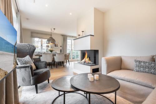 a living room with a couch and a fireplace at Ferienhaus Finoah - Leben, Luxus, Leichtigkeit hinter der Duene in Westerland Sylt in Westerland (Sylt)