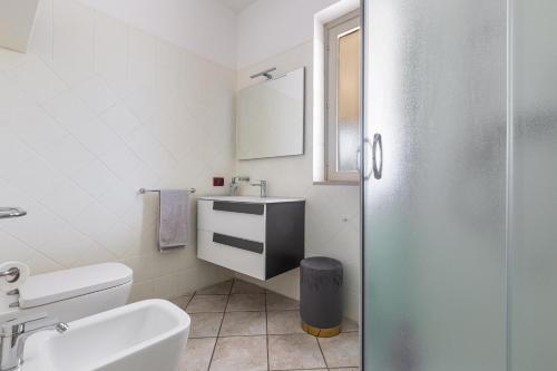 ein weißes Badezimmer mit Waschbecken und Toilette in der Unterkunft Villa Goccia by BarbarHouse in Torre dell'Orso