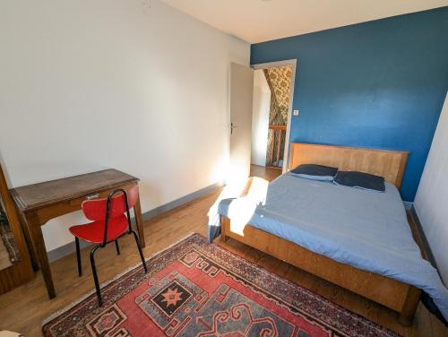 - une chambre avec un lit, un bureau et une chaise rouge dans l'établissement Ferme Bigourdane, à Poueyferré