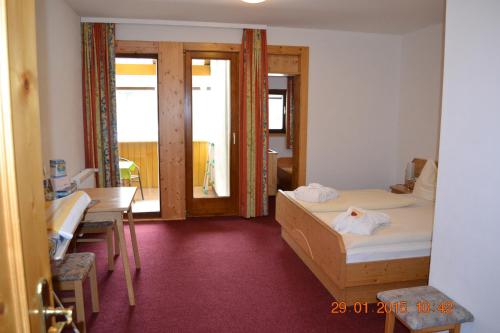 a room with a bed and a desk and a table and a room with at Pirker's Natur- & Bio Familienhotel in Malta