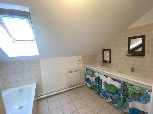 un bagno con lavandino e vasca da bagno di Le Grimaubois a Hurbache