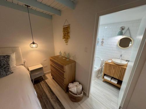 パーム・イーグル・ビーチにあるMeraki Apartment Bungalowのベッドのある寝室と洗面台のある浴室