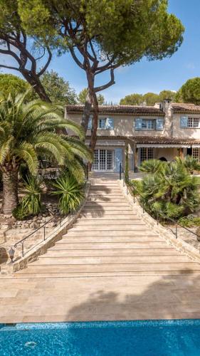 une maison avec un escalier menant à une piscine dans l'établissement Villa Les Palmier's, à Mouans-Sartoux