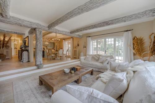 un salon avec des meubles blancs et une table dans l'établissement Villa Les Palmier's, à Mouans-Sartoux