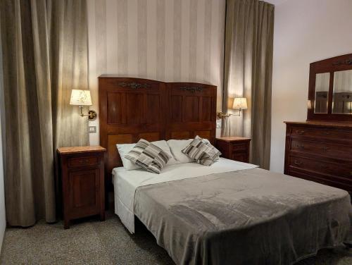 a bedroom with a large bed with two pillows at VILLA ANTONIETTA Rooms & Coffee in Cesenatico