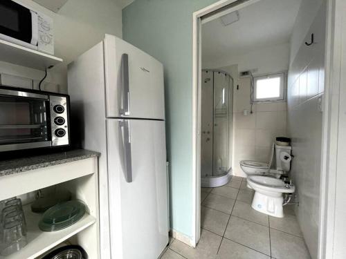 a kitchen with a refrigerator and a toilet and a microwave at EKÜ Chapa Tiny House - Playa Luna Roja in La Estafeta