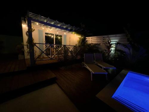 a balcony with two chairs and a table at night at Meraki Studio in Oranjestad, Aruba in Palm-Eagle Beach