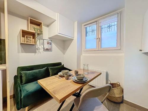 - un salon avec une table et un canapé vert dans l'établissement My home perrache, à Lyon