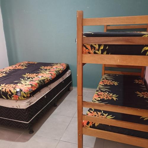 a bedroom with two bunk beds and a ladder at casa de praia ReJ 2 in Itapoa