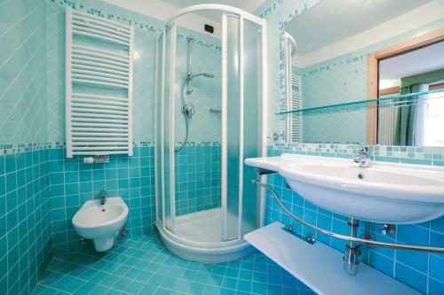 a blue bathroom with a sink and a shower at Nivis Hotel in Folgarida