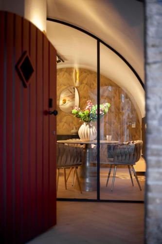 a dining room with a table with a vase of flowers at The Stork - In luxe logeren aan de Oudegracht, Centrum Utrecht in Utrecht