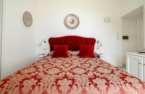 a red bed with two red pillows on it at La Dolce Vita Ravello - Two Bedroom Apt with Sea View Terrace in Ravello