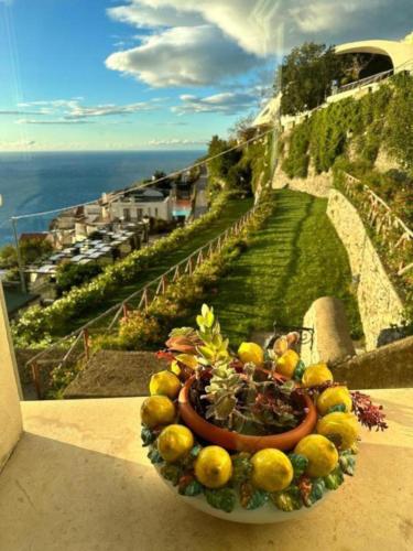 a bowl of fruit on the ledge of a balcony at La Dolce Vita Ravello - Two Bedroom Apt with Sea View Terrace in Ravello