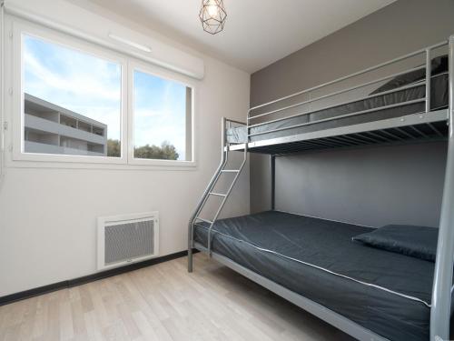 une chambre avec un lit superposé et une fenêtre dans l'établissement La Dune 41 - VILLA 4P7, à Valras-Plage