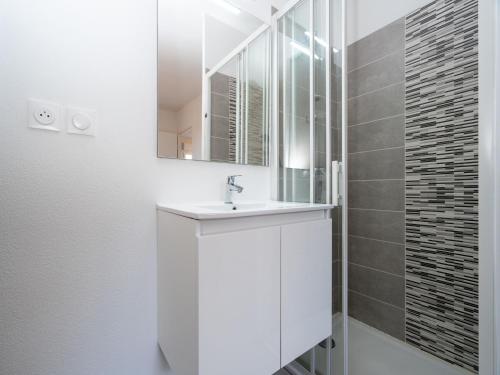une salle de bain blanche avec un lavabo et un miroir dans l'établissement La Dune 41 - VILLA 4P7, à Valras-Plage