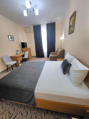 a bedroom with a large bed in a hotel room at Vila Verde in Chişinău