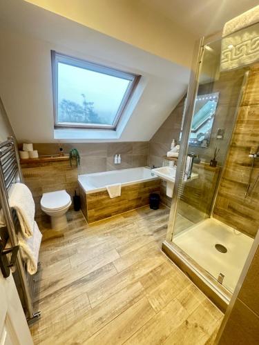 a bathroom with a tub and a toilet and a shower at The Inn At Grasmere in Grasmere