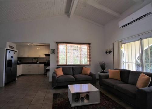 a living room with two couches and a table at Paradera Paradise - your ultimate 5-bedroom getaway in Paradera