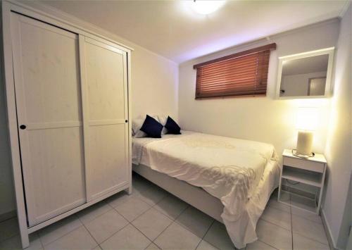 a small bedroom with a bed and a window at Paradera Paradise - your ultimate 5-bedroom getaway in Paradera