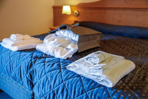 a bed with towels on it with a box on it at Nivis Hotel in Folgarida