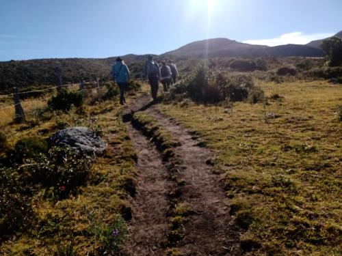 a group of people walking down a dirt road at Alojamiento Anita Habitaciòn in Monguí