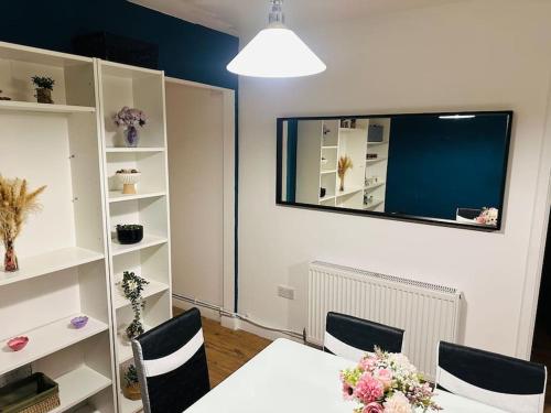 a dining room with a table and chairs and a mirror at Comfortable stay in Wembley in London
