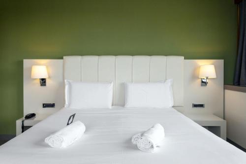 a large white bed with two white pillows on it at B&B HOTEL Trapani Crystal in Trapani