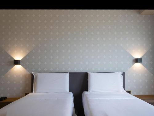two beds sitting next to each other in a room at B&B HOTEL Trapani Crystal in Trapani