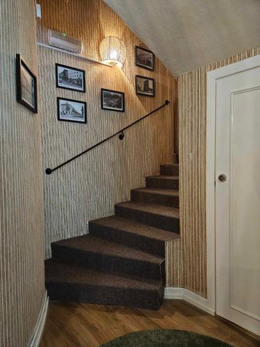 a staircase in a home with pictures on the wall at Lilla Älvbrogården i stan in Avesta