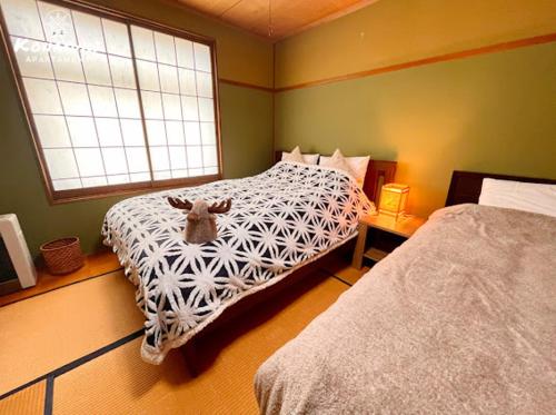 a bedroom with a bed with a goat on it at KONAYUKI Apartment in Myoko