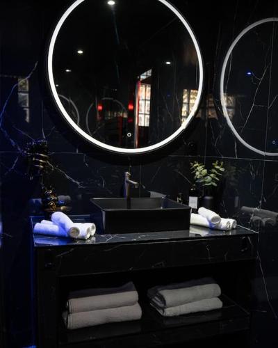 a bathroom with a sink and a mirror and towels at Découvrez la Suite Mirage à 30 minutes de Paris in Pontoise