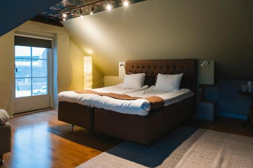 a bedroom with a large bed with white pillows at Köpmans Boutique Hotel & Bistro in Höganäs