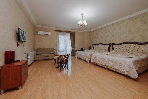 a bedroom with a bed and a table and a chair at Natali Hotel in Borjomi