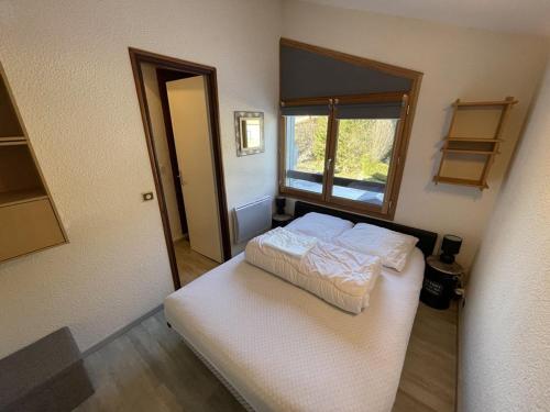 une petite chambre avec un lit et une fenêtre dans l'établissement Appartement fonctionnel 4.5 pers, proche pistes et commerces, balcon exposé Sud-Est - FR-1-787-82, à Laveissière