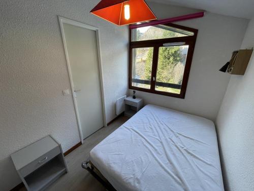 une petite chambre avec un lit et une fenêtre dans l'établissement Charmant T2 cabine au Lioran, balcon sud-est, 4 personnes - FR-1-787-98, à Laveissière