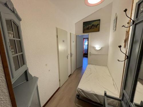 - un couloir avec un lit dans une chambre dans l'établissement Charmant T2 cabine au Lioran, balcon sud-est, 4 personnes - FR-1-787-98, à Laveissière