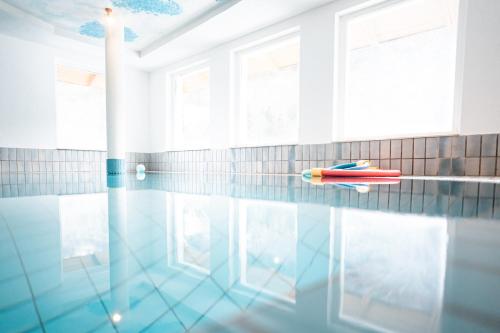 a swimming pool with a pool noodle in the water at Pirker's Natur- & Bio Familienhotel in Malta