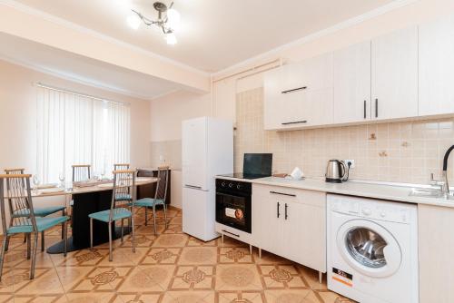 a kitchen with a washer and dryer and a table at ERA RENT Apartments in Chişinău