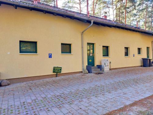 a yellow building with a green door on it at Ferienhaus Waldschneise B am Jabeler See in Jabel