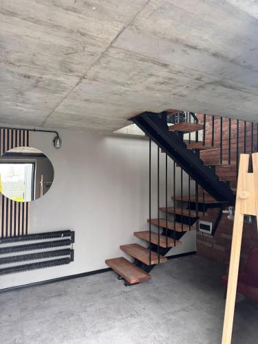 a staircase in a room with a white wall at Apartamenty Stodoła in Kajkowo