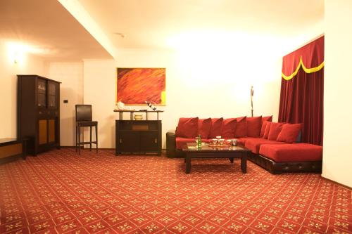 a living room with a red couch and a table at Phoenicia Grand Hotel in Bucharest