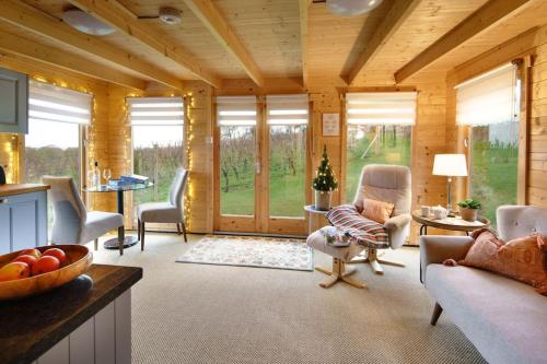 a large living room with wooden walls and windows at Vineyard lodge in Herefordshire in Ledbury