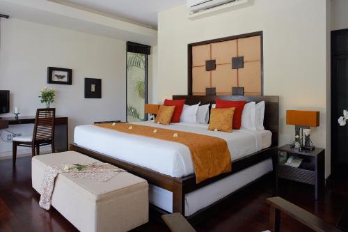 a bedroom with a large bed and a desk at Temple Hill Residence Villa in Jimbaran