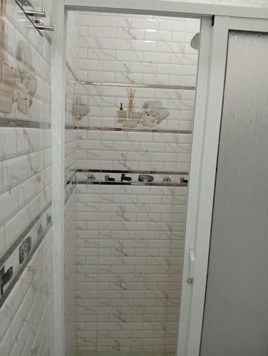 a bathroom with a shower with white brick walls at Appartement bien équipé et calme in Tangier
