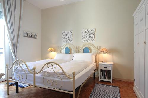 a bedroom with a white bed with two lamps at Catullo 18 Apartment, Lago Di Garda, Jacuzzi in Desenzano del Garda